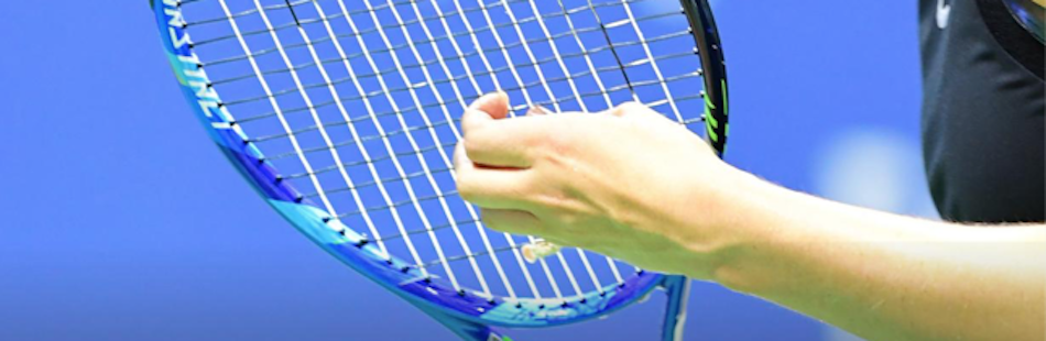 stagiaires de tennis adultes qui replace les cordes de sa raquette pendant un stages de tennis dans le Val d'allos